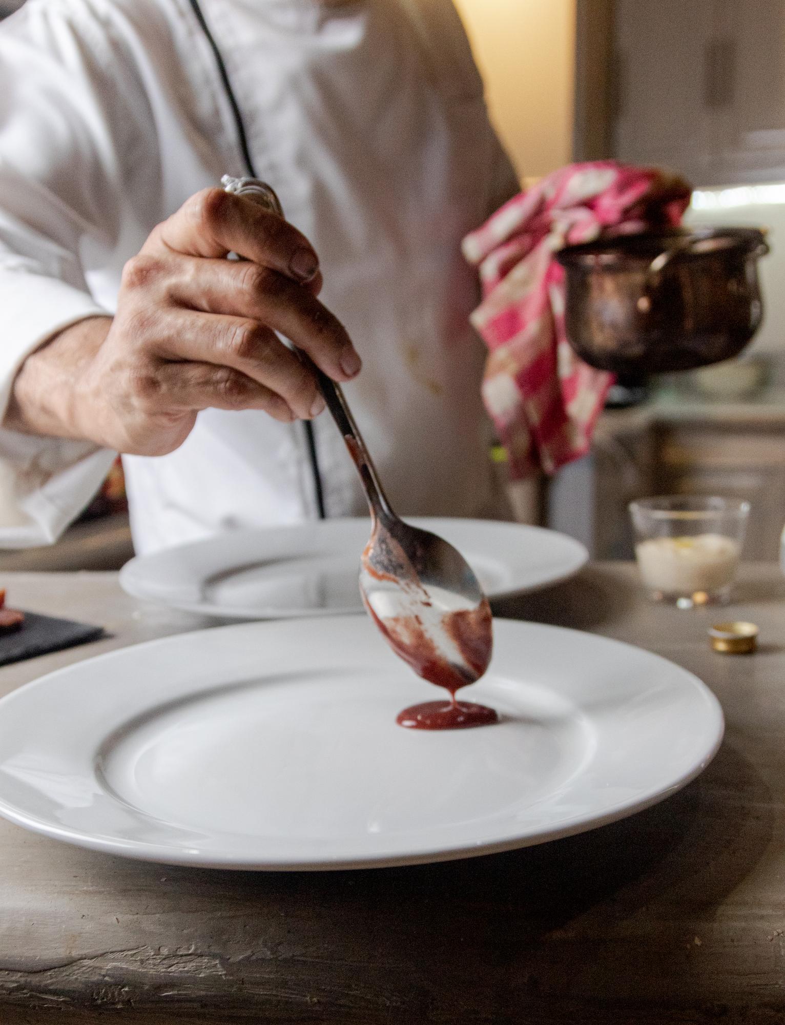 Close-up of hands plating a dessert
